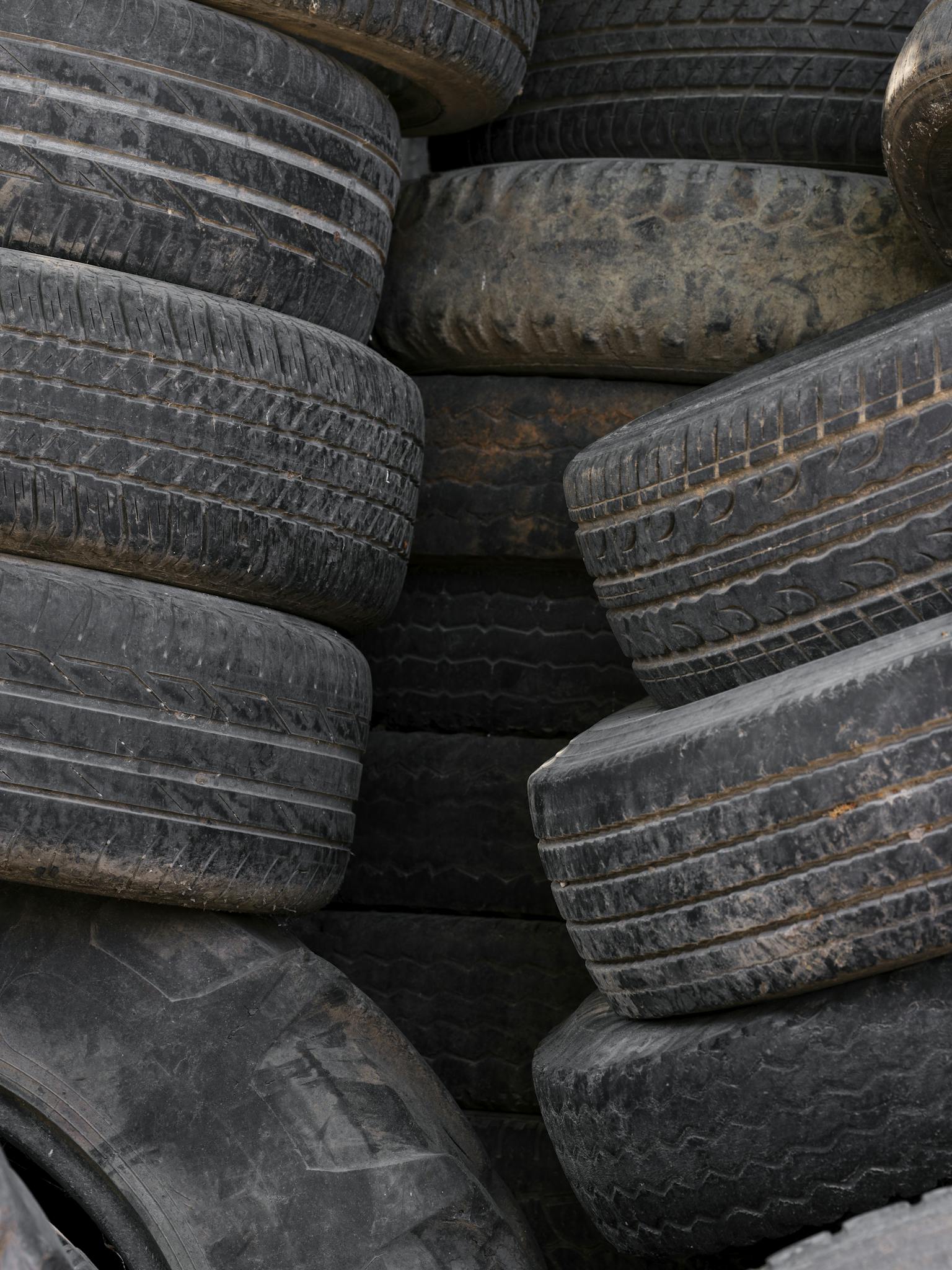 A stack of used tires ready for recycling, highlighting the industrial waste management process.