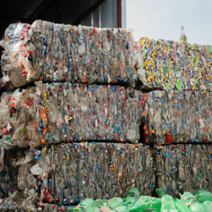 Stacked compressed plastic bottles at a recycling facility, ready for processing.